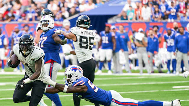 Oct 8, 2023; London, United Kingdom; Jacksonville Jaguars running back Travis Etienne Jr. (1) escapes a tackle from Buffalo Bills defensive end Leonard Floyd (56) during the second half of an NFL International Series game at Tottenham Hotspur Stadium.